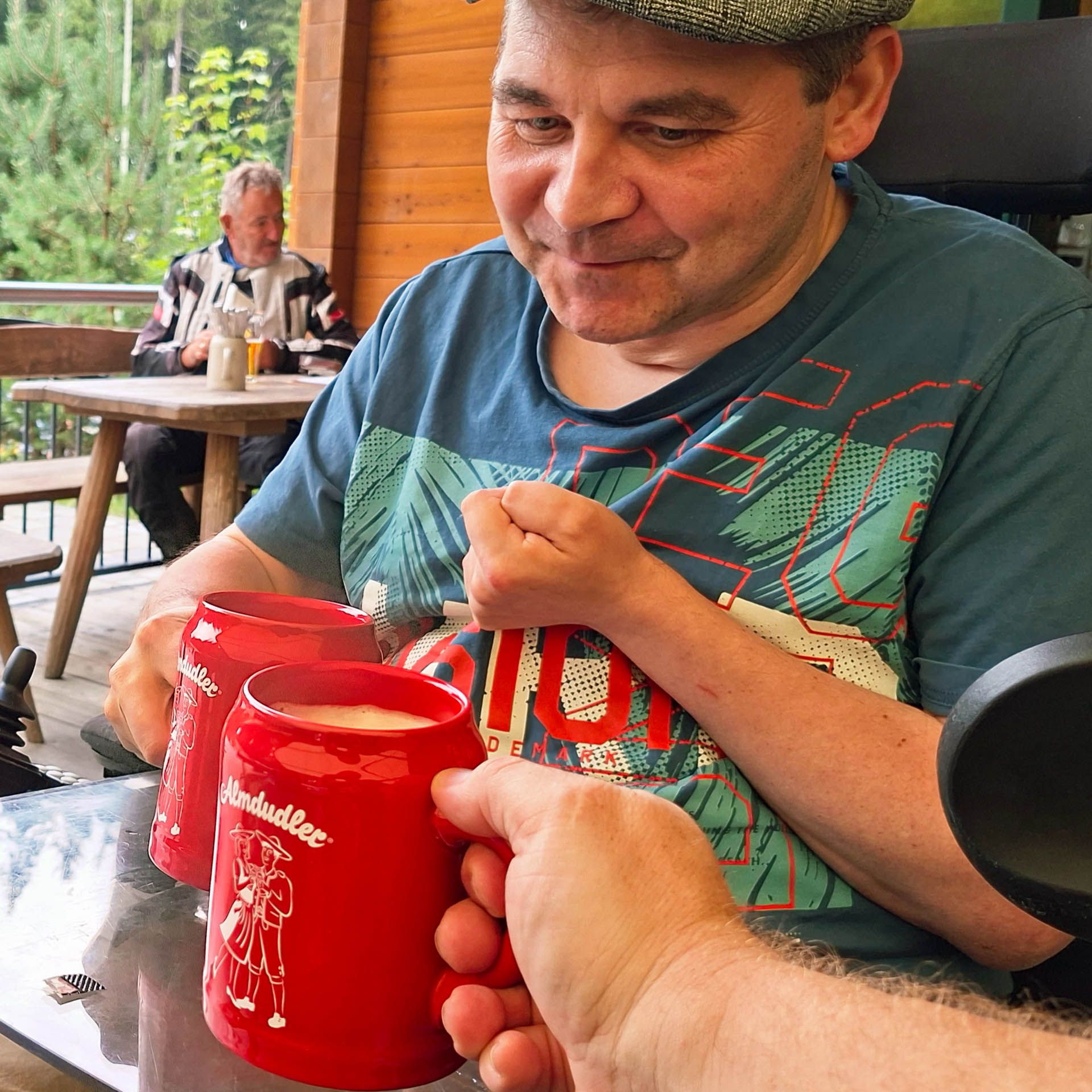 Helmut prostet mit seinem Bruder mit feuerroten Bierkrügen